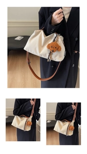 Detail of beige canvas tote with brown leather strap and cute puppy plush charm