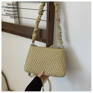 Detail of olive green quilted handbag with scrunchie strap and extra shoulder strap