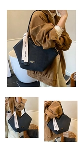 Detailed view of herringbone texture and V-cut top on this large black tote bag