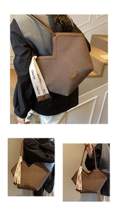 Close-up of brown herringbone tote bag featuring leather logo tag and decorative ribbon