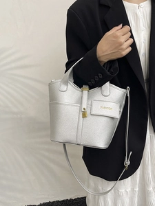 Silver lychee grain bucket bag with gold lock shown in a stylish fashion setting