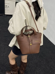 Brown lychee leather bucket bag with brass lock and adjustable shoulder strap