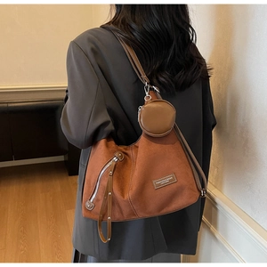 Brown suede versatile shoulder bag with a round coin purse and side zipper detail