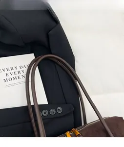 Détail du sac cabas en daim marron foncé avec fermeture éclair dorée et fines bandoulières