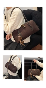 Détail d'un sac bandoulière en daim marron foncé avec un pendentif en forme de chocolat