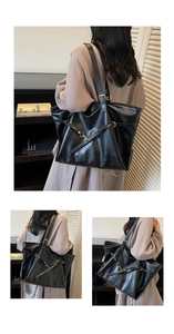 Detail of a large black PU leather tote bag with gold hardware and adjustable strap