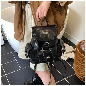 Detail of vintage black leather backpack with flap closure and silver buckle pockets