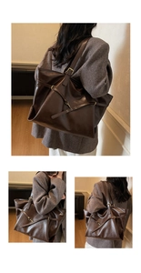 Detail of dark brown vintage tote bag with decorative cross straps and gold hardware