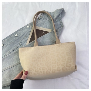 Flat lay of leopard print suede tote bag with slim handles and spacious interior design