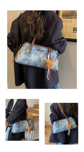 Detail of vintage blue textured shoulder bag with plush bear charm and striped strap