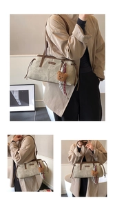 Detail view of khaki green retro shoulder bag with plush bear charm and brown handles