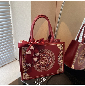 Détail du sac cabas de mariée rouge avec broderie de dragon dorée et nœud en soie