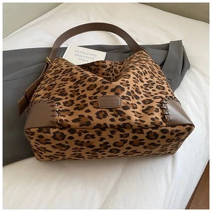 Detail of leopard print hobo bag showing brown leather strap and fine stitching