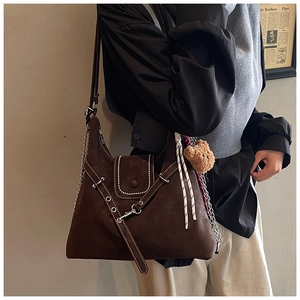 Brown faux suede shoulder bag featuring a metal chain strap and cute plush bear charm