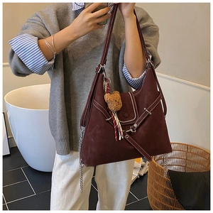 Detailed view of burgundy frosted leather tote with contrast stitching and bear charm