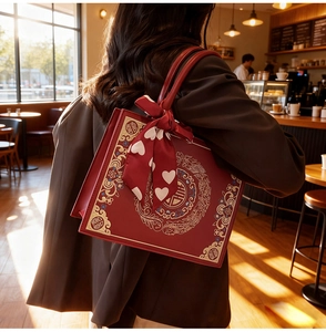 Détail du sac de mariage rouge avec broderie dorée et foulard en soie sur la poignée
