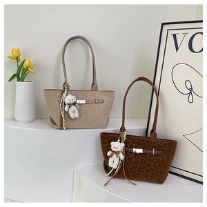 Detail of leopard print suede tote bags with belt buckles and plush bear charms