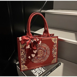 Détail du sac de mariage rouge avec broderie dorée, symbole Double Bonheur et foulard en soie