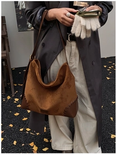 Detail of brown suede tote bag featuring contrast stitching and smooth leather panel