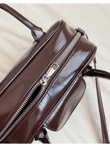 Detailed close-up of smooth oil-wax leather texture and silver zipper on the bowling bag