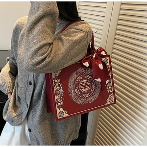 Détail du sac à main rouge avec broderie dragon-phénix et symbole traditionnel de mariage