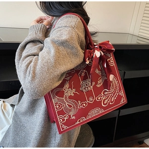 Détail du sac de mariage chinois rouge avec broderie de dragon phénix doré et signe Xi