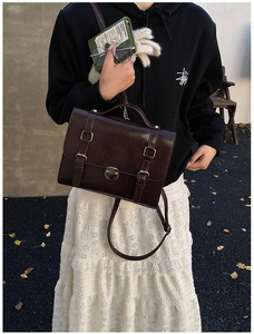 Borsa a tracolla retrò marrone scuro indossata da una modella in uno stile urbano