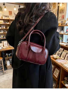 Burgundy oiled leather bowling bag shown with handle and adjustable shoulder strap
