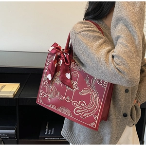 Détail du sac de mariage rouge avec broderie dragon phénix et caractère traditionnel Xi