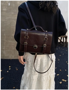Dettaglio della borsa a tracolla vintage marrone scuro con fibbie metalliche sul modello