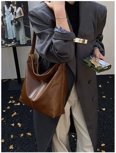 Détails d'un grand sac seau en cuir marron avec texture mate et boucle dorée élégante