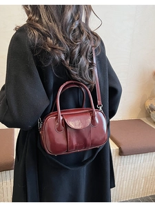 Deep red oily wax leather bowling bag with LULU embossing on black wool coat