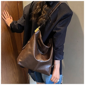 Détail du sac seau vintage marron avec surpiqûres contrastées et grande capacité d'accueil