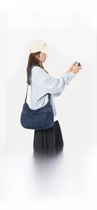 Detail of blue denim crossbody bag with high-quality washed texture and functional zipper