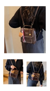 Detail of dark brown leather backpack with contrast stitching and teddy bear charm