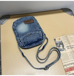 Detail of vintage blue denim crossbody bag with 7Street Game leather patch and snap pocket