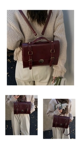 Foto all'aperto di uno zaino vintage in pelle rosso scuro con varie opzioni di trasporto