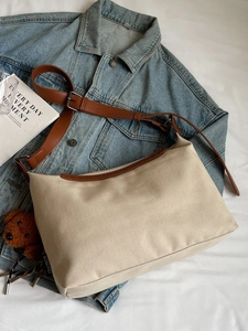Beige canvas tote bag with brown leather straps and cute plush bear charm decoration