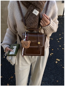 Sacoche vintage en cuir marron avec coutures ondulées et porte-clés ours mignon