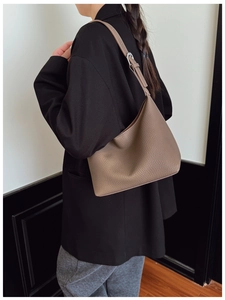 Detail of dark brown pebble leather shoulder bag showing adjustable metal buckle strap