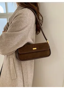 Sac sous le bras en daim marron foncé avec boucle dorée et manteau d'automne
