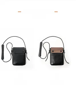 Vertical minimalist crossbody phone bag in black and brown two-tone color display