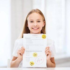 Round honeybee reward stickers for kids shown on student paper with positive feedback