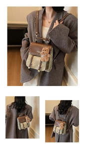 Λεπτομέρεια vintage backpack με χρωματικές αντιθέσεις, αγκράφες και κρεμαστό αρκουδάκι