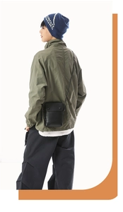 Detailed view of a black minimalist leather crossbody phone bag shown on a model