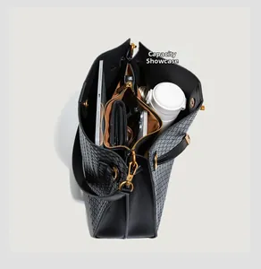 Interior capacity display of black woven tote bag with daily essentials and gold hardware