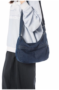 Adjustable denim hobo bag featuring a crescent shape and front zipper pocket detail