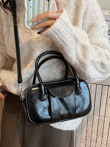Classic black patent leather bowling bag with glossy finish and detachable shoulder strap