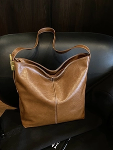 Sac seau vintage en cuir marron avec surpiqûres blanches et boucle dorée