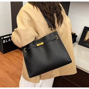 Detail of woven leather shoulder bag showing intricate Intrecciato texture and gold hardware
